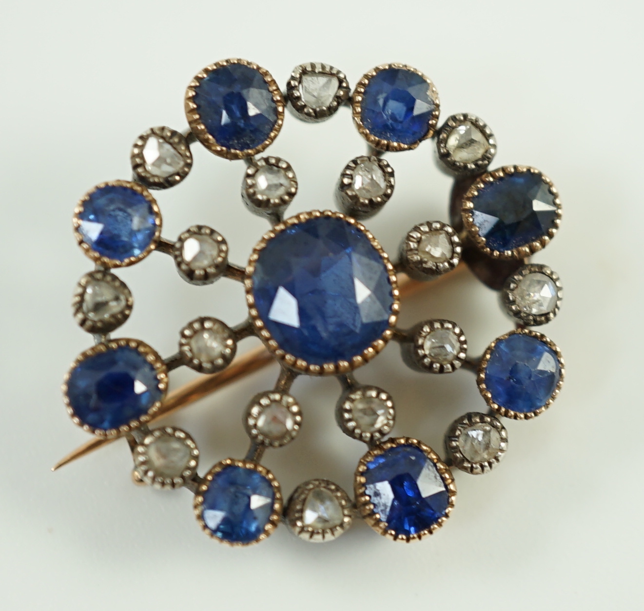 A Belle Epoque gold and silver, sapphire and diamond cluster set circular brooch